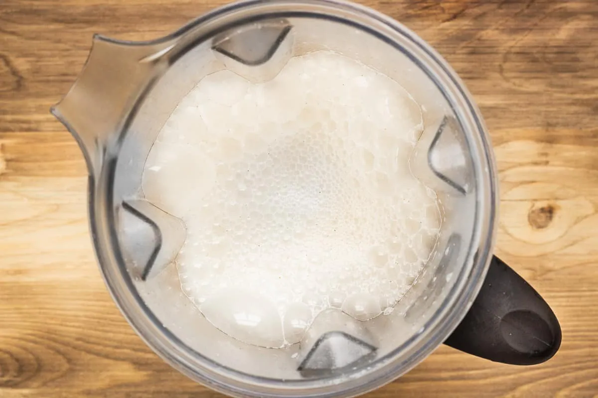 Image shows a blender just full of freshly made dairy-free beverage.