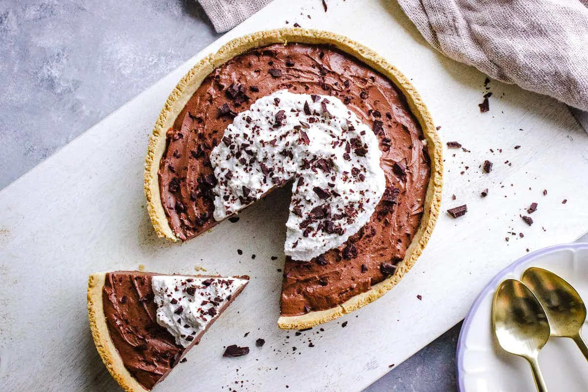 Overhead shot of 8-Ingredient Vegan Chocolate Pie topped with whipped coconut cream and shaved chocolate.