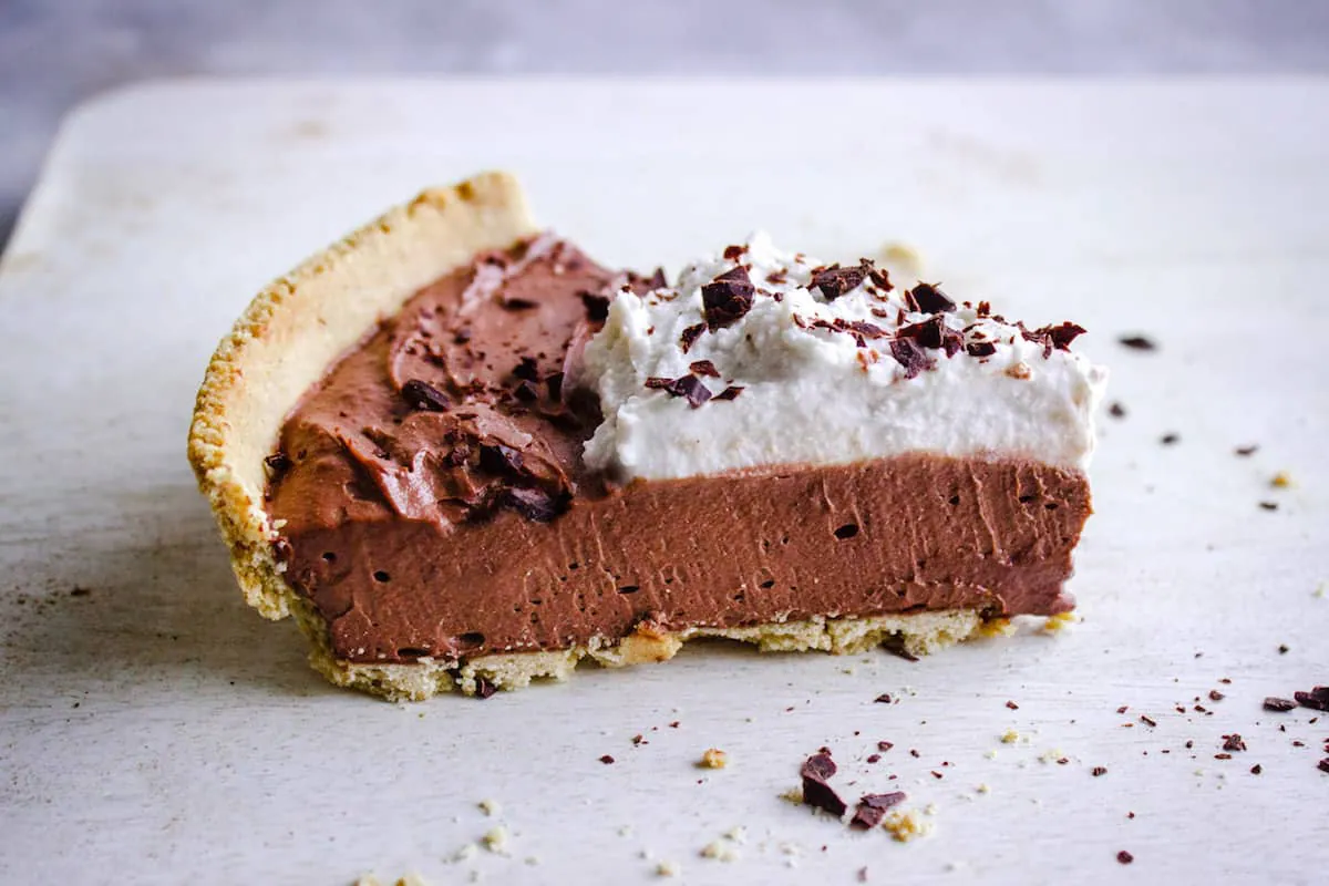 Close up shot of 8-Ingredient Vegan Chocolate Pie topped with whipped coconut cream and shaved chocolate.