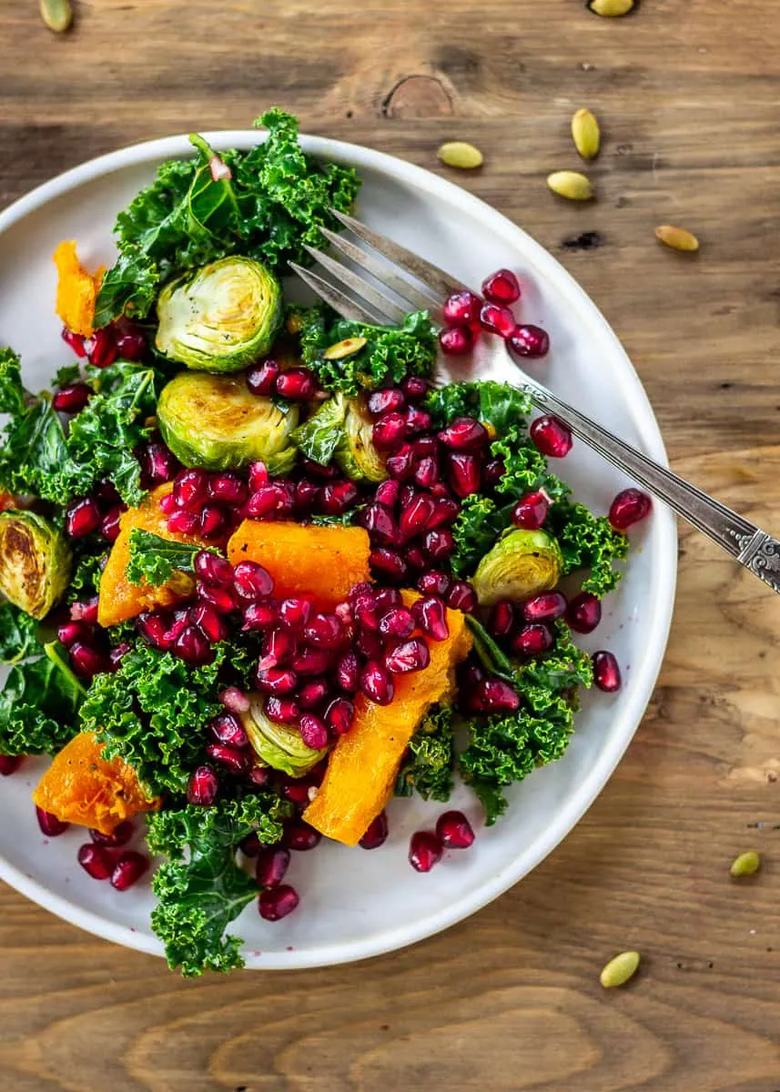 Bright coloured winter salad of Brussels sprouts, butternut squash, kale and pomegranate.