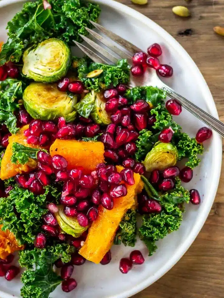 Bright coloured winter salad of Brussels sprouts, butternut squash, kale and pomegranate.