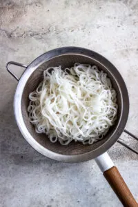 Rice noodles in a sieve.