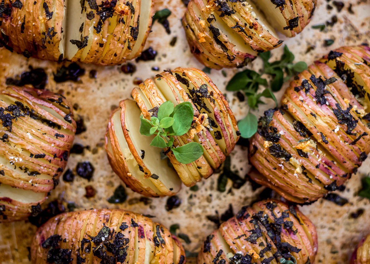 Overhead image of Sage & Garlic Hasselback Potatoes on a baking tray by Vancouver with Love.