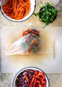 Vegan Spring Roll being wrapped in rice paper wrapper.
