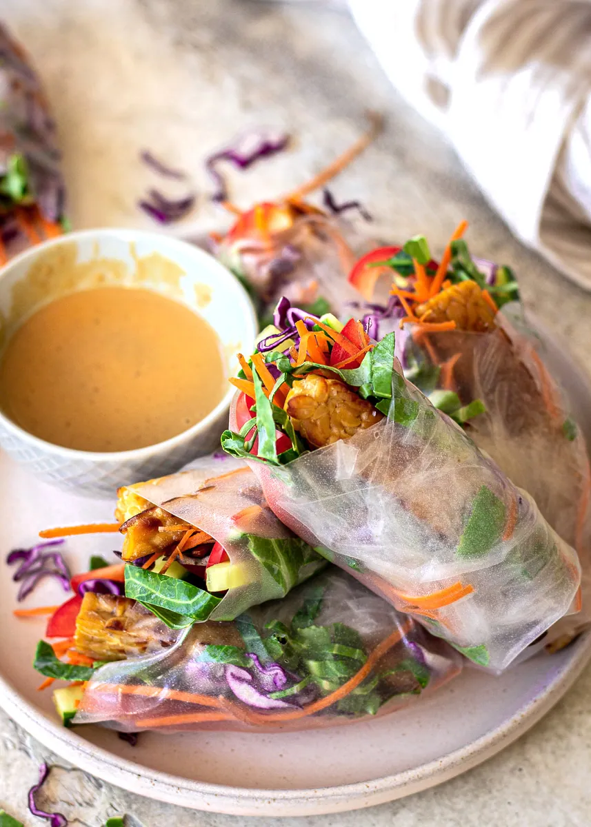 Rice paper rolls accompanied by a dish of peanut sauce.