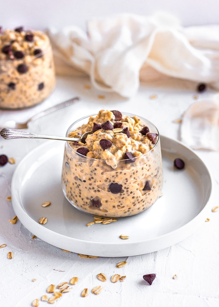 Overnight oats with chocolate chips in a glass jar with a spoon.