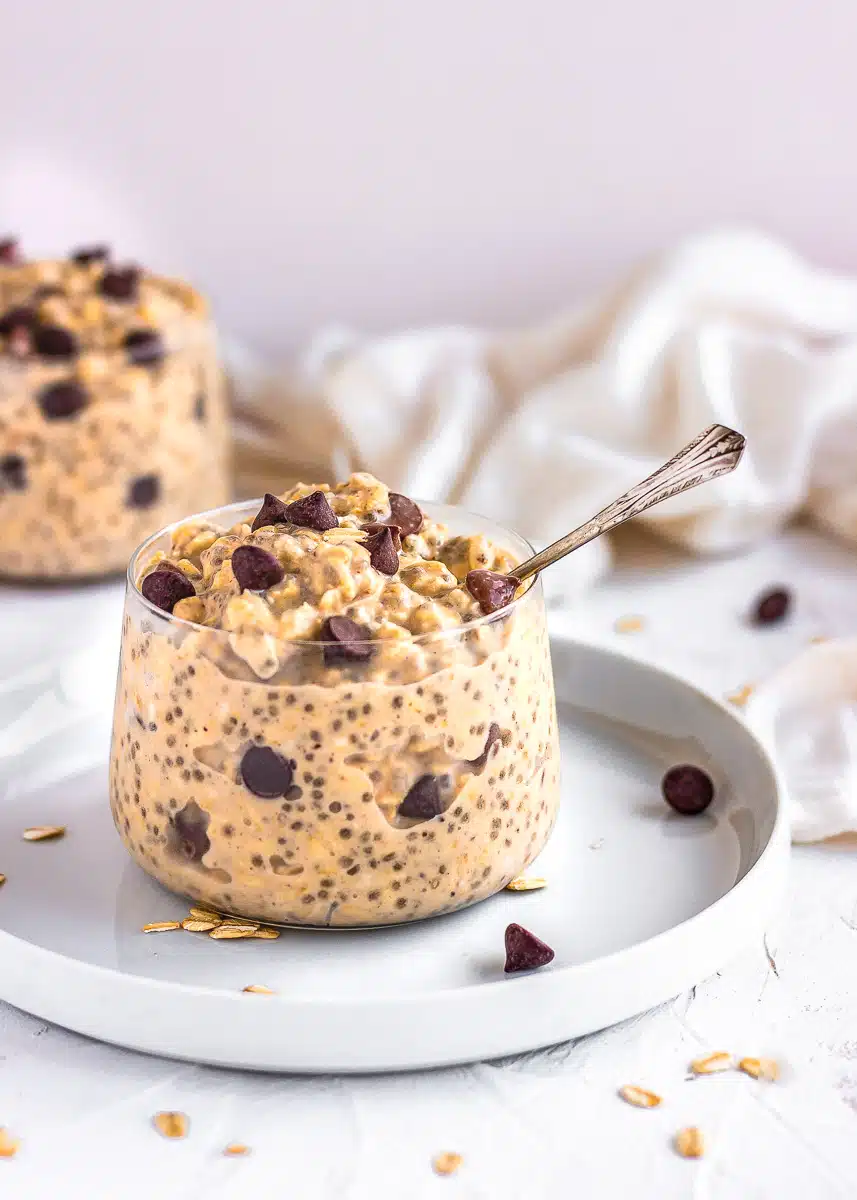 Cookie Dough Overnight Oats in glass jar with a spoon.