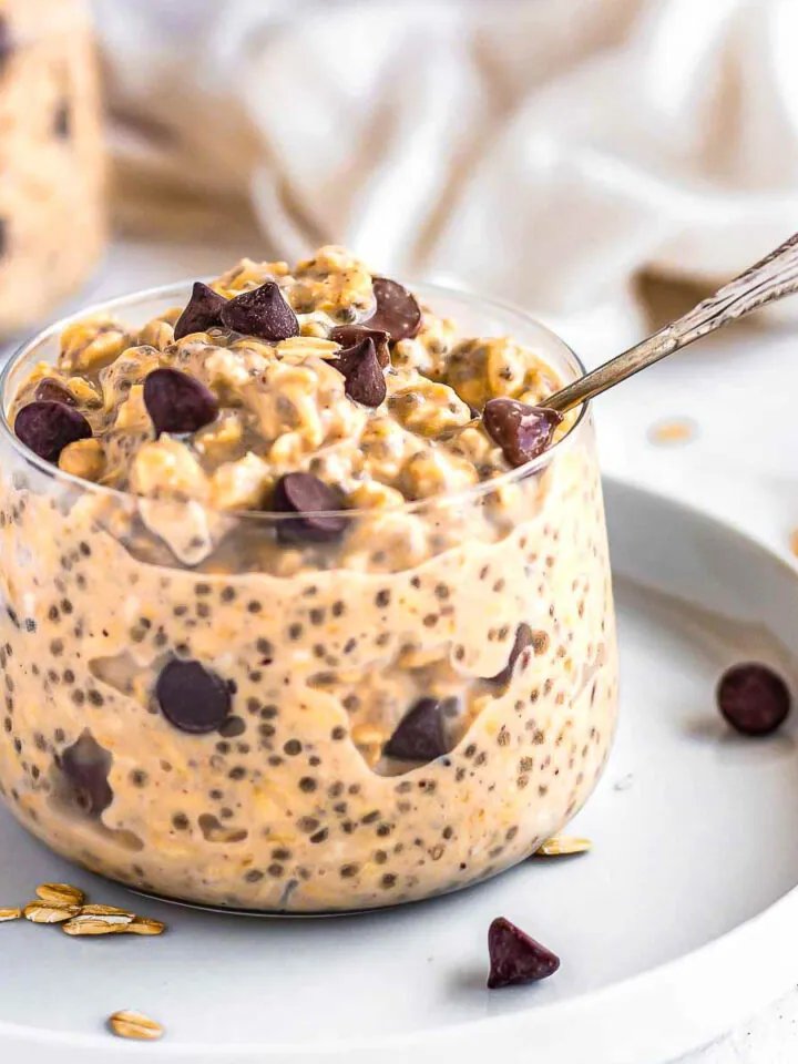 Cookie Dough Overnight Oats in a glass jar with chocolate chips.