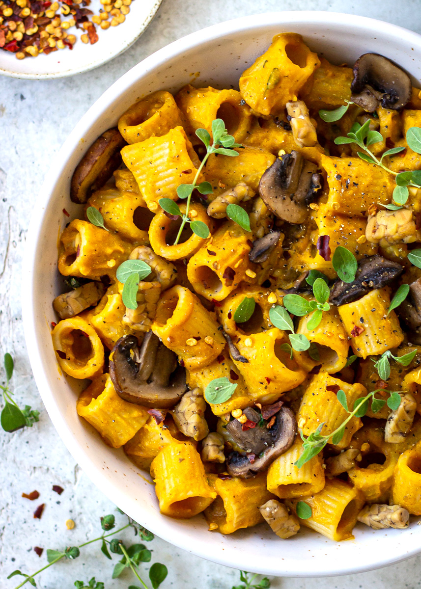 Overhead view of vegan cheesy pasta with mushrooms and tempeh