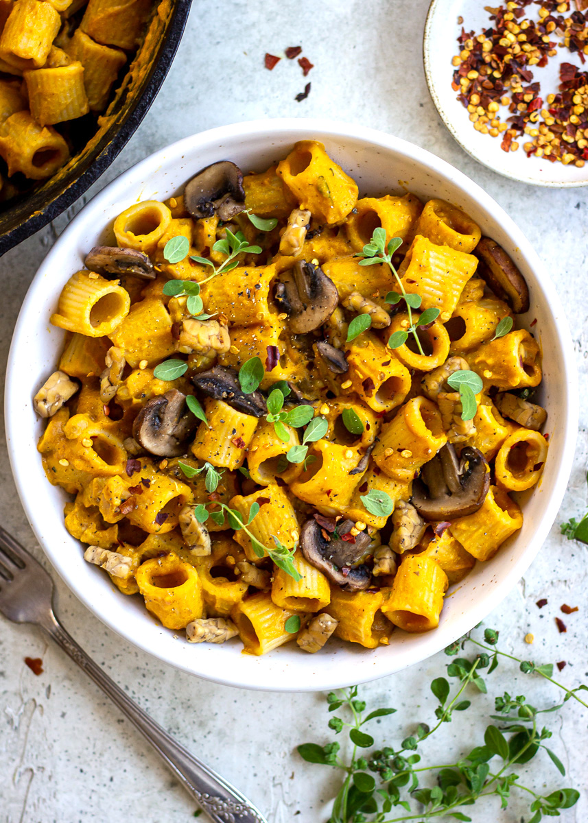 Overhead view of vegan cheesy pasta with mushrooms and tempeh