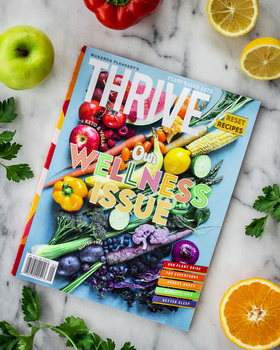 Overhead view of front cover of Thrive magazine, showing an image of colourful fruits and vegetables.