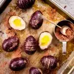 Vegan creme eggs on baking tray with cocoa powder.