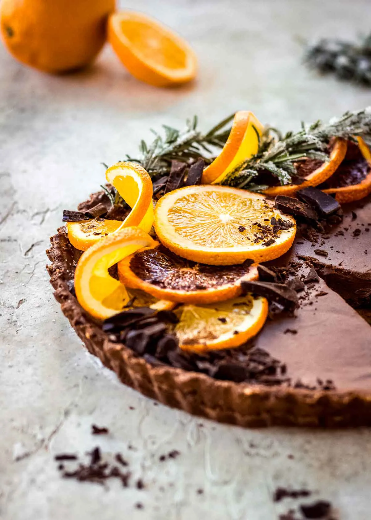 Closeup of chocolate and orange tart decorated with multicoloured orange slices and chocolate.