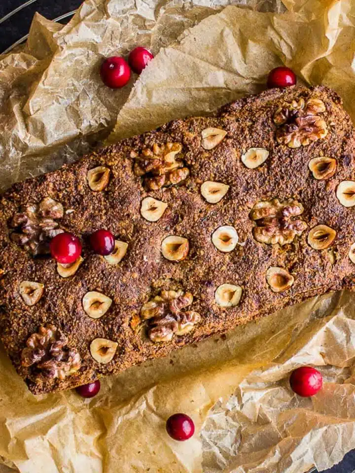 Classic Vegan Nut Roast on baking parchment decorated with cranberries.