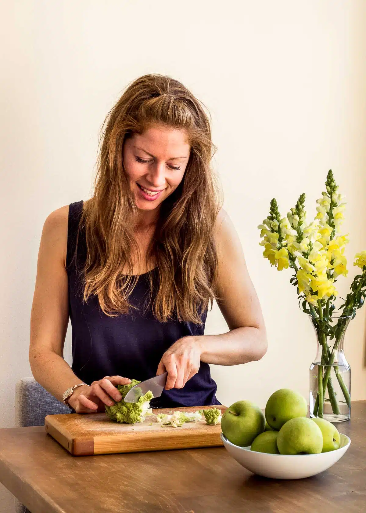 Elizabeth Emery of Vancouver with Love sitting at a kitchen table chopping up vegetables.