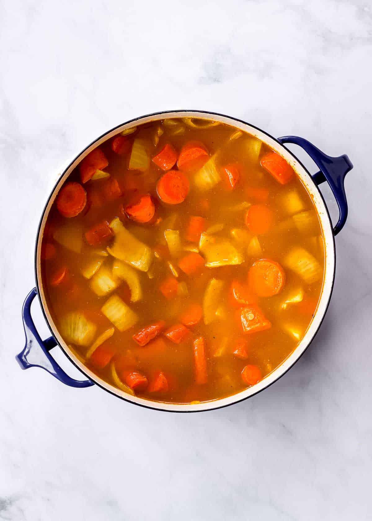 Carrots, onion, garlic, spices, lentils and vegetable broth in a large pot.