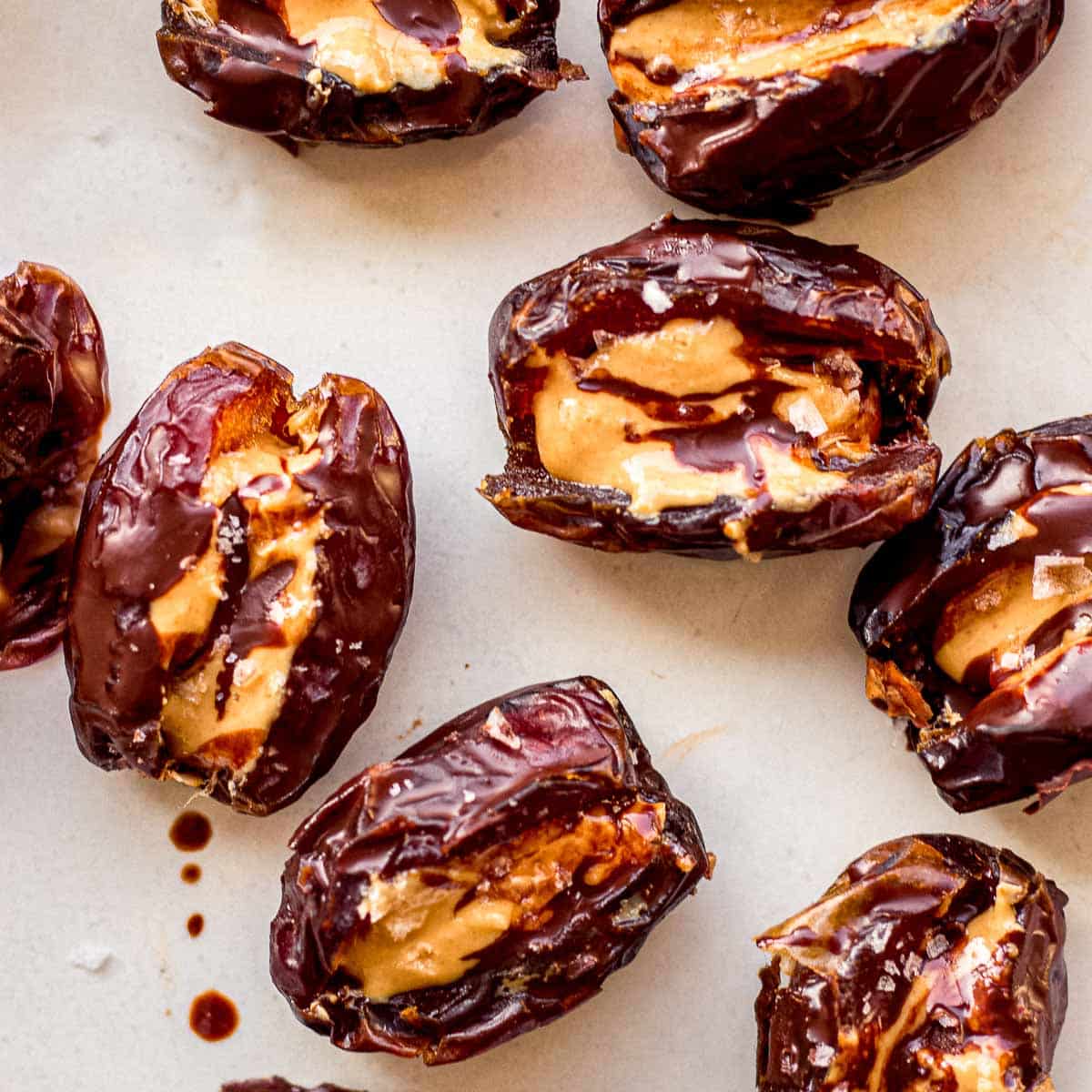 Overhead image of dates stuffed with peanut butter, and sprinkled with dark chocolate and sea salt.