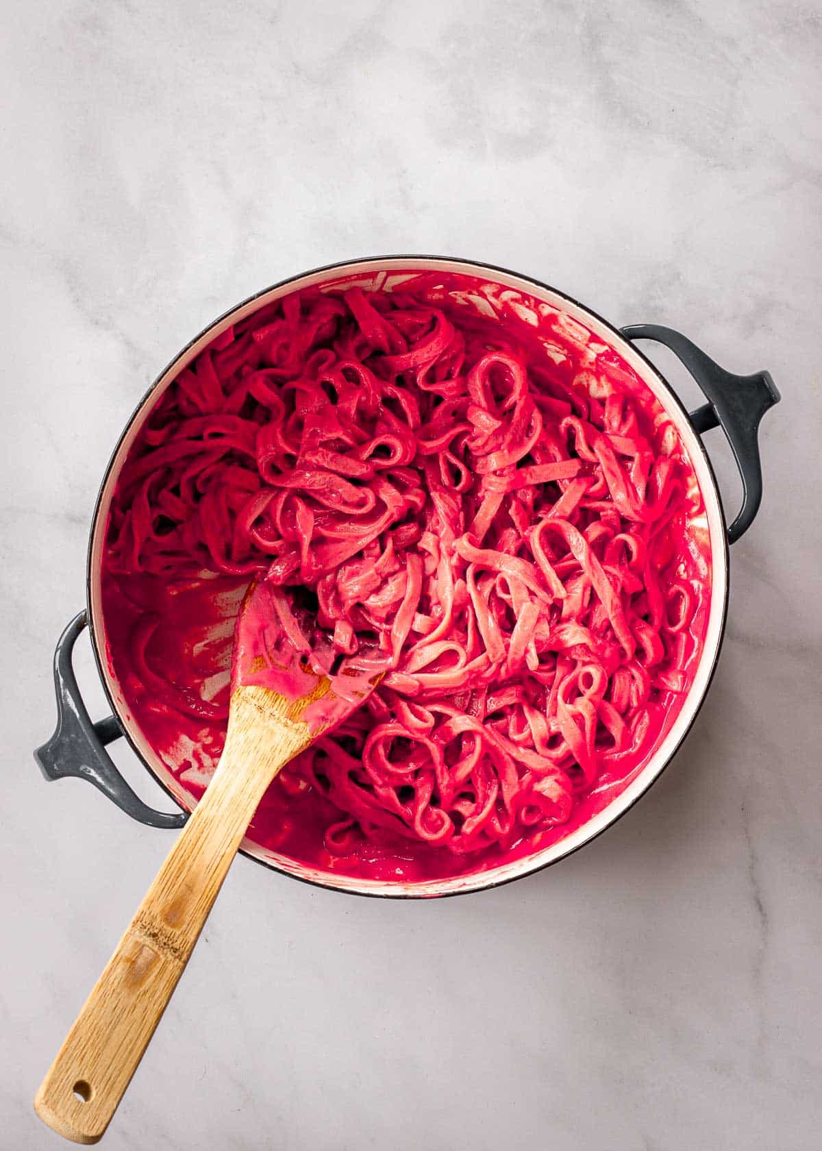 Large pot containing fettuccini in a pink sauce.
