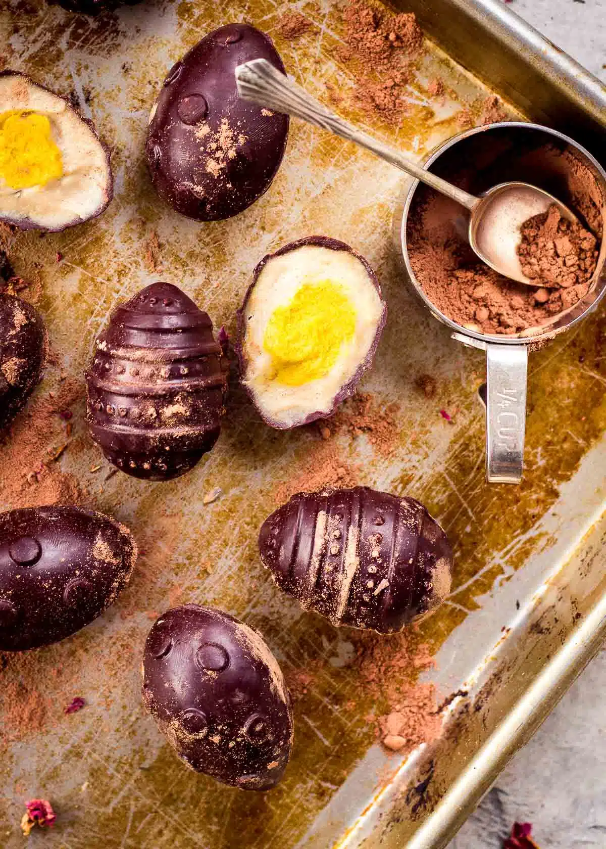 Vegan creme eggs with measuring cup of cocoa powder.