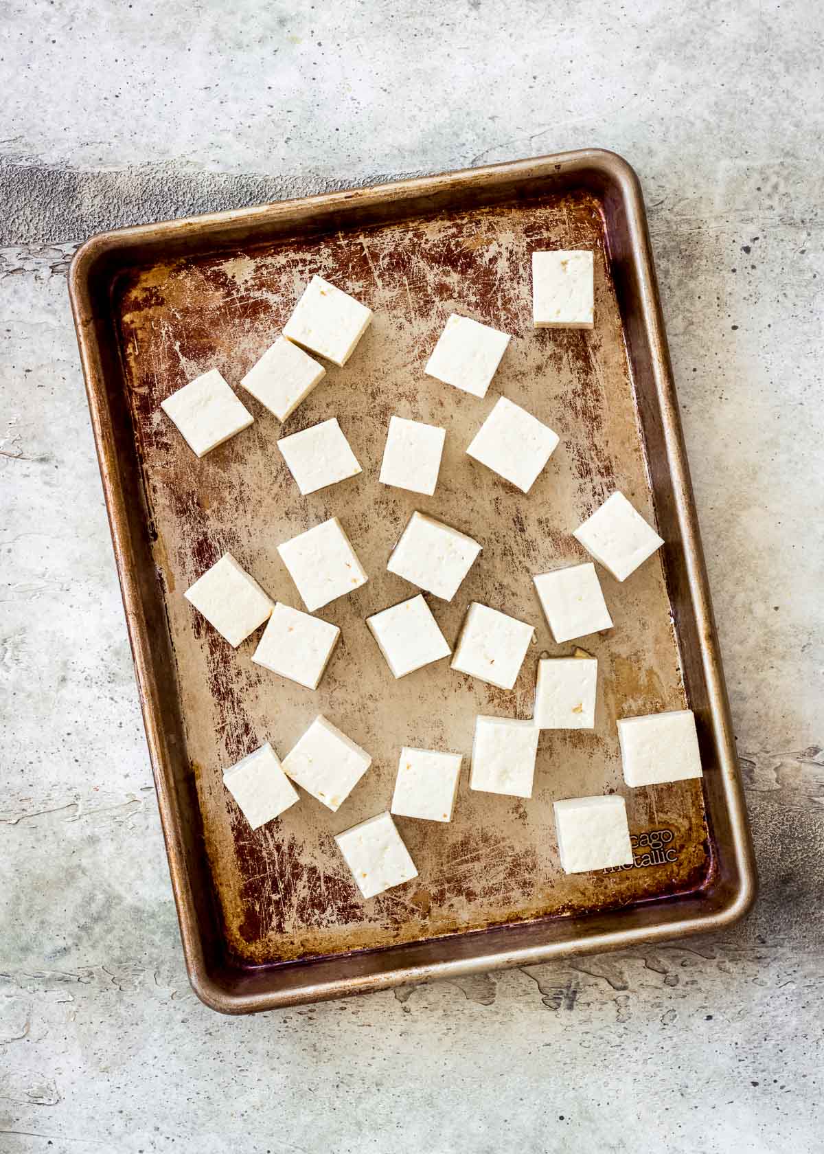Tray of uncooked cubed tofu ready to be broiled.