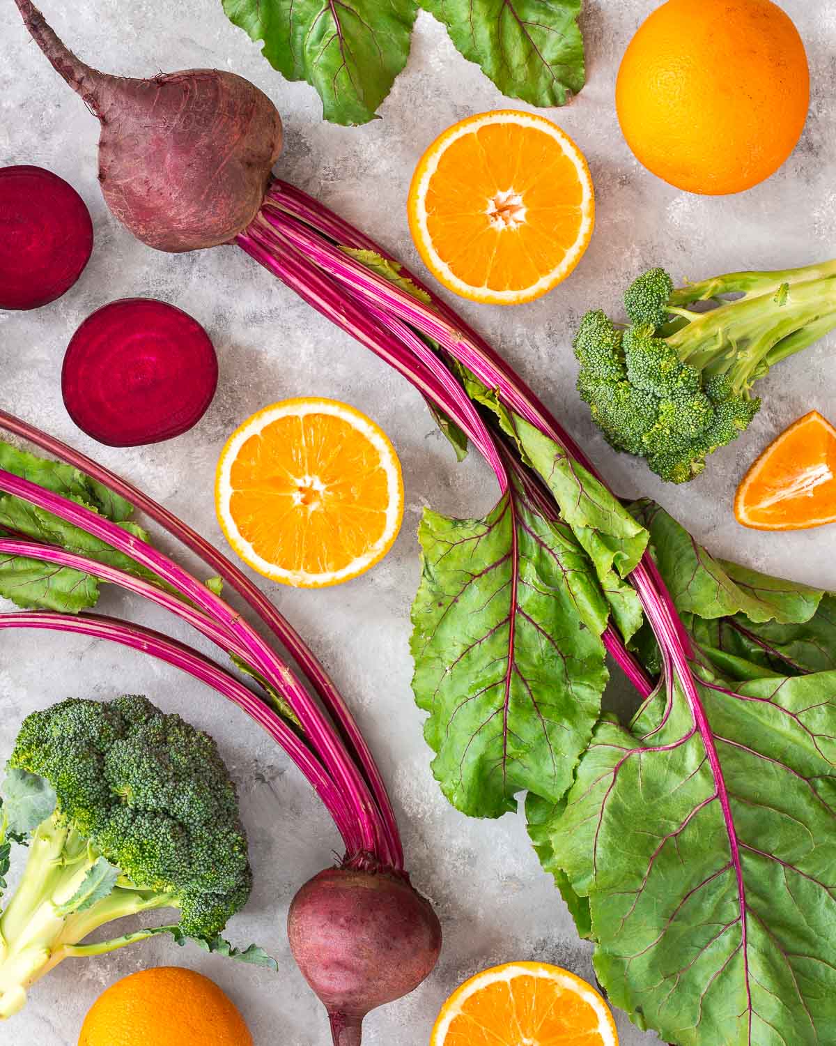 Overhead image of sliced oranges, beets and broccoli florets.