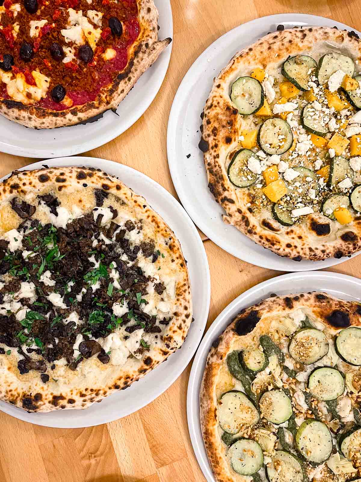 25 Best Vegan Restaurants in Vancouver BC for 2023 - image of four pizzas from Grano Pizzeria