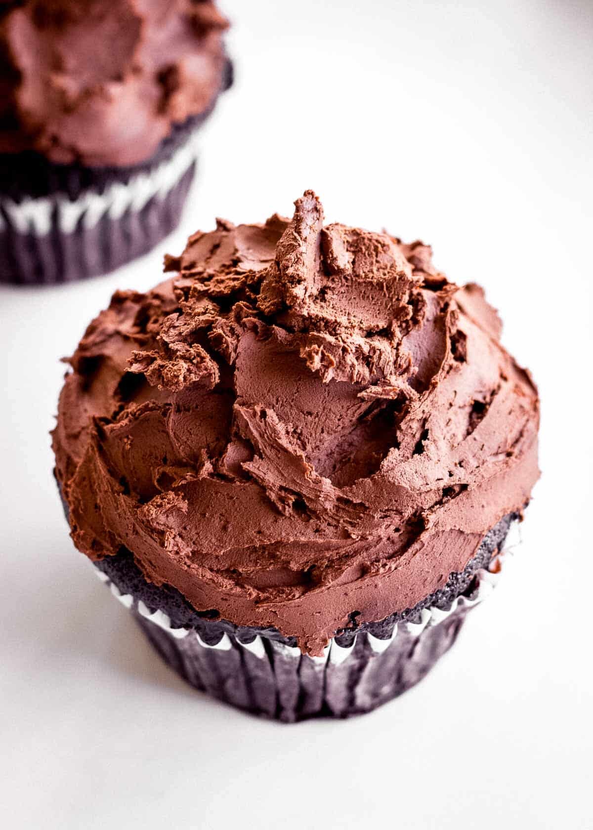A chocolate cupcake decorated with vegan dark chocolate ganache.