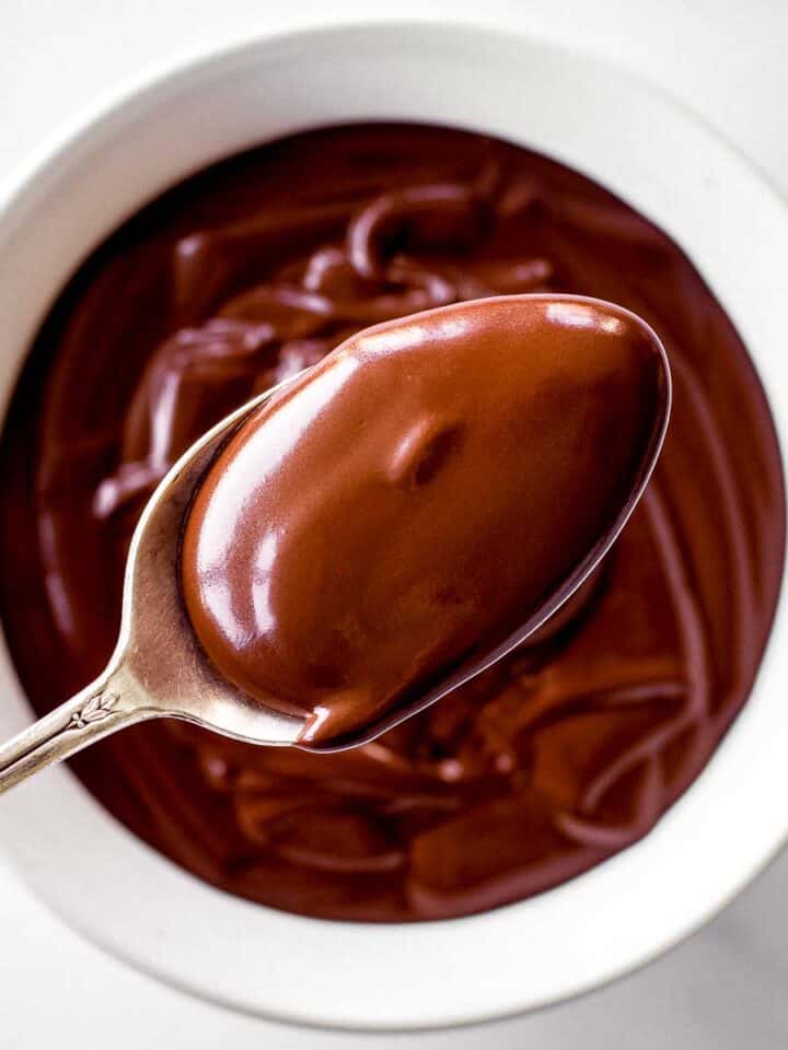A spoonful of coconut milk chocolate ganache above a bowl filled with it.