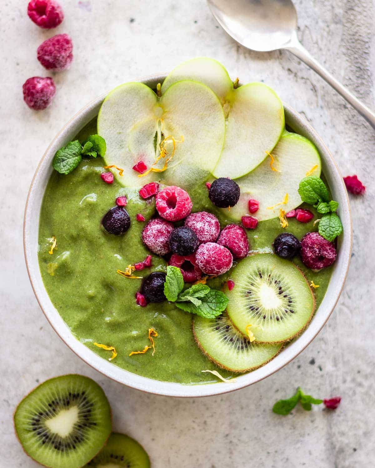 Green smoothie bowl with apple, kiwi and berries.