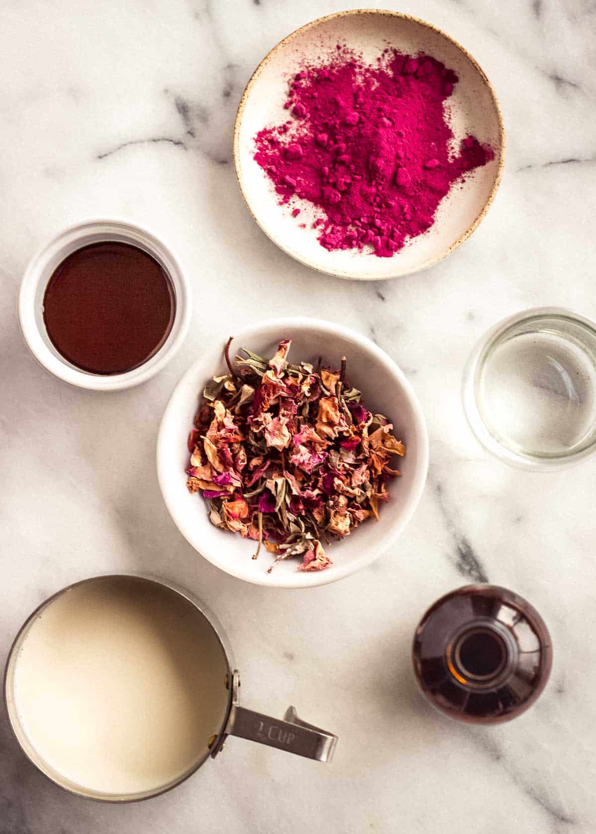 Ingredients to make a rose latte, including beet powder, rose water and milk.