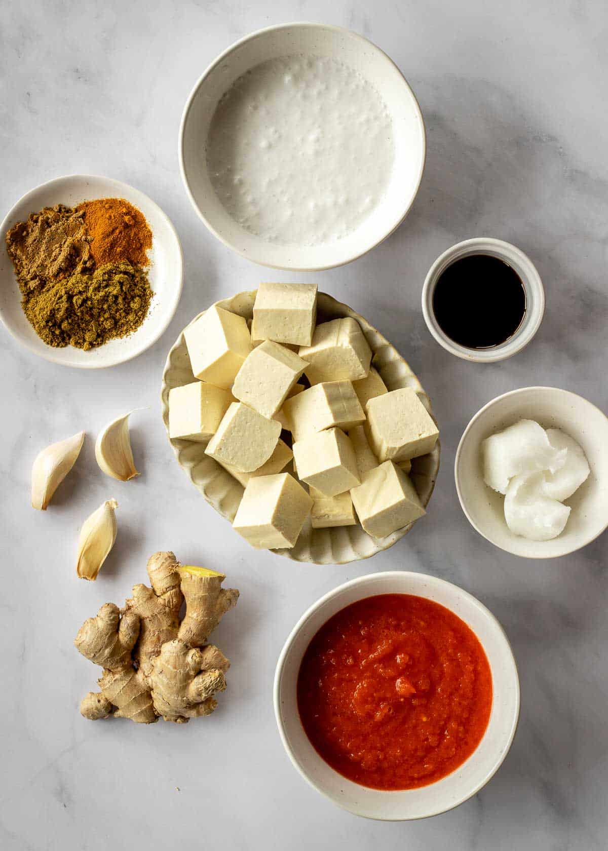 Ingredients for vegan butter chicken, including tofu, coconut milk, spices and crushed tomatoes.