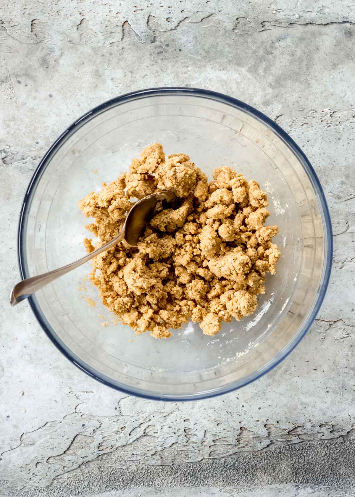 Oats, peanut butter and maple syrup being mixed together in a glass bowl to form the snickers bar recipe base.